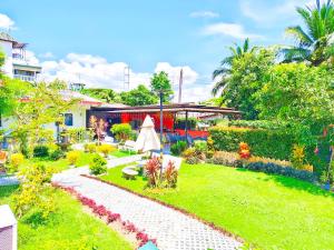 a garden with a table and a umbrella in the grass at Suki Palm in Ban Bang Chak