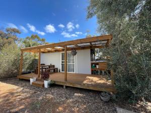 a small house with a deck in the woods at Self Contained Cabin in Nildottie