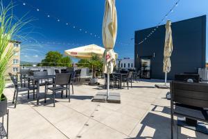 a patio with tables and chairs and an umbrella at Primma Hotel in Moldava nad Bodvou