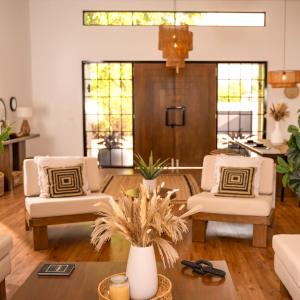 a living room with two white chairs and a table at Heaven Retreat with Minigolf, pool, fire pit, BBQ in Nadi +38 photos