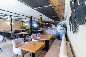 a restaurant with tables and chairs and a bar at Primma Hotel in Moldava nad Bodvou