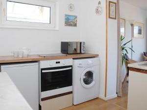 a kitchen with a washing machine and a microwave at Peel Wyke in Keswick +9 photos