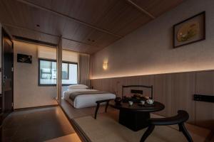 Un dormitorio con una cama, una mesa y una silla. en Changsha Pushe Minsu, en Changsha