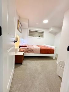 a small bedroom with a bed and a window at Cozy 2 Bedroom Suite Close to Amenities in Edmonton +28 photos