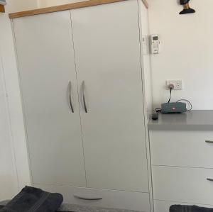 a white cabinet with silver handles in a kitchen at Self Contained Cabin in Nildottie