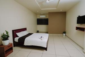 CalicutAtland Residency的一间带床和平板电视的卧室