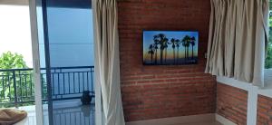 a brick wall with a picture of palm trees at Amed Sari Beach Guesthouse in Amed