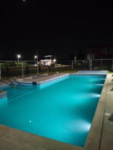 a large blue swimming pool at night at Anjanadri Lakeview Gardens - Sapthashree Nivasa in Hosūr