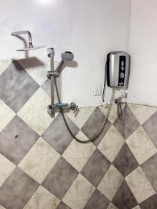 a shower in a bathroom with a television on the wall at Wave Loom Hostel Ahangama in Ahangama