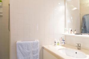 ポルト・チェルボにあるVilletta Il Mirtoの洗面台と鏡のある白いバスルーム