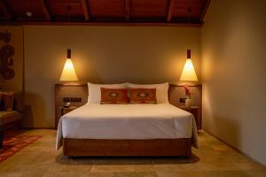 Greenpark Resort and Spa, Madikeri في ماديكيري: غرفة نوم بسرير كبير مع مصباحين +21 صورة