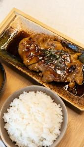 a plate of food with meat and rice on a table at Curve Boutique Hotel in Pattaya Central