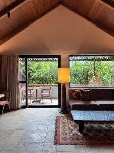 Greenpark Resort and Spa, Madikeri في ماديكيري: غرفة معيشة بها أريكة وطاولة