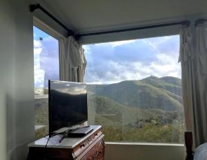Schlafzimmer mit einem großen Fenster mit Bergblick in der Unterkunft Pet Friendly Charming Cottage with Incredible Views and Hot-tub in Rainbow, California in Rainbow