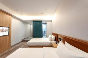 een hotelkamer met twee bedden en een tv bij Borrman Hotel Jiangyin Zhouzhuang in Xiwujieqiao +222 foto's