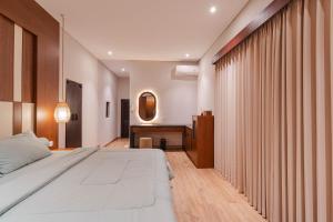 a bedroom with a bed and a desk at Jiwandari House Bali in Darmasaba