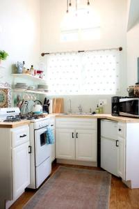 eine Küche mit weißen Schränken und einer Spüle in der Unterkunft Pet Friendly Charming Cottage with Incredible Views and Hot-tub in Rainbow, California in Rainbow
