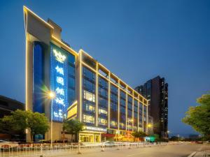 a large building with lights on the side of it at Echarm Hotel Zhangjiajie Tianmen Mountain High-speed Railway Station in Zhangjiajie