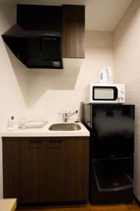 une cuisine avec un évier et un micro-ondes dans l'établissement 康郷 箱根湯本, à Hakone