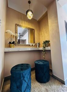 een kamer met een spiegel en twee blauwe krukken bij PANAH luxe in Guwahati