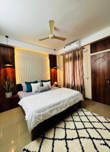 een slaapkamer met een groot bed en een plafondventilator bij PANAH luxe in Guwahati