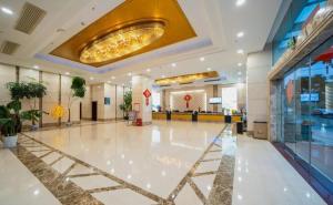 a lobby with a large white floor and a chandelier at Bashan Hotel in Xiamen