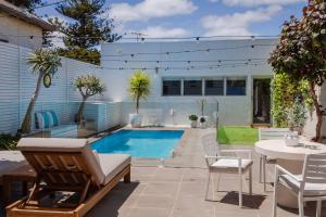 a patio with a pool and a table and chairs at Belle Escapes - Villa Luxe on Henley in Henley Beach