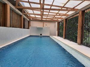 an indoor swimming pool with a wooden ceiling at Hôtel Restaurant Gites Kribi in Kribi +12 photos