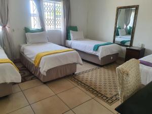 une chambre avec deux lits et un miroir dans l'établissement Ntoliwa Bed and Breakfast, à Suits Me
