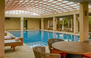Greenpark Resort and Spa, Madikeri في ماديكيري: مسبح بطاولة وكراسي وطاولة وطاولة