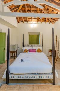 un dormitorio con una cama grande en una habitación en The Project Cafe and Hotel, en Aldona