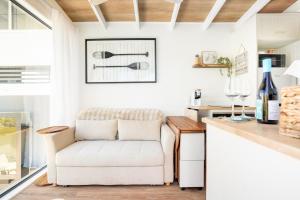 a living room with a white chair and a counter at Tiny Home in the heart of Broadbeach-River Views! in Gold Coast +17 photos