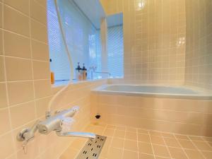 a bathroom with a bath tub and a sink at 花の街660 Tsumagoi Private House with Parking & BBQ in Tsumagoi +36 photos