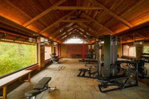 Greenpark Resort and Spa, Madikeri في ماديكيري: صالة ألعاب رياضية مع العديد من أجهزةالجري ونافذة كبيرة