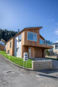 a house with a sign in front of it at Ruru Retreat- Free Parking- Hot Tub- Walk To Town in Queenstown