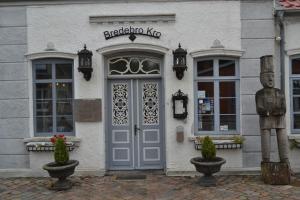
a brick building with a blue door and windows at Bredebro Kro in Bredebro
