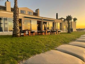 a building with a table and benches in front of it at The Sunset Villas in Velddrif