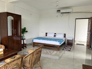 1 dormitorio con 1 cama y sillas en una habitación en The Ashvem Horizon, en Mandrem