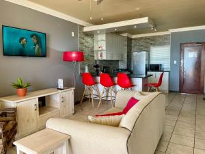 a living room with a couch and red chairs at The Sunset Villas in Velddrif