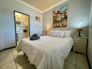 a bedroom with a large white bed and a bathroom at The Sunset Villas in Velddrif +31 photos