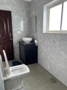 Un baño con lavabo, inodoro y ventana. en The Ashvem Horizon, en Mandrem 3 fotos más