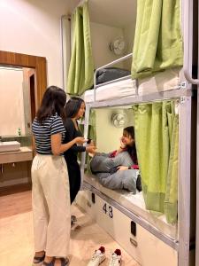 a group of people standing in a hospital bed at Konnect Inn-New Delhi Railway Station in New Delhi