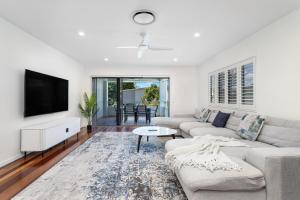 un salon avec un canapé et une télévision dans l'établissement Palm Beach Perfection - Luxe Coastal Escape, à Gold Coast