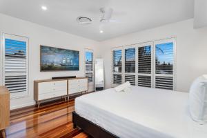 - une chambre blanche avec un grand lit et des fenêtres dans l'établissement Palm Beach Perfection - Luxe Coastal Escape, à Gold Coast 22 autres photos