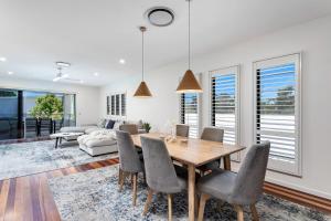 une salle à manger avec une table, des chaises et un canapé dans l'établissement Palm Beach Perfection - Luxe Coastal Escape, à Gold Coast