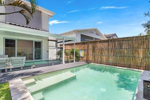 une piscine dans l'arrière-cour d'une maison dans l'établissement Palm Beach Perfection - Luxe Coastal Escape, à Gold Coast