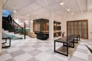 a lobby with a table and a staircase in a building at Urbanview Hotel Bonetta Lampung by RedDoorz in Kedaton