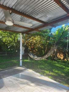 a patio with a hammock in a yard at La Villa Ti'Lau in Saint-Laurent du Maroni