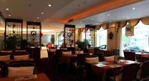 a restaurant with tables and chairs in a room at Hedong Hotel in Shenzhen