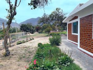 a garden with flowers and a brick building at ESTANCIA don VICTOR 